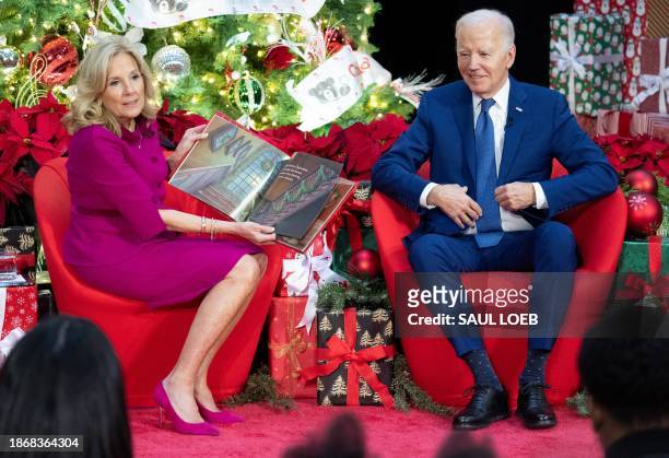 President Joe Biden sits next to First Lady Jill Biden as she reads "'Twas The Night Before Christmas" during a holiday visit to patients and...