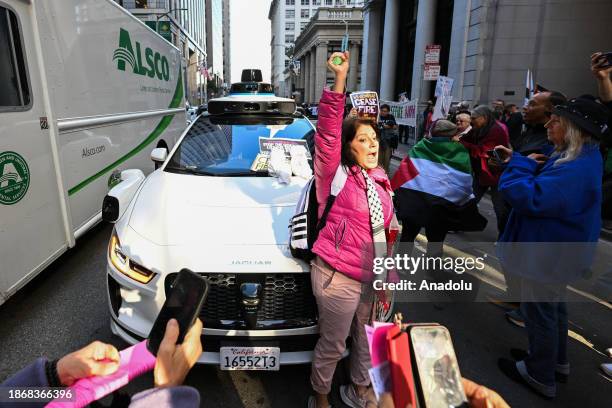 Waymo autonomous taxi stuck during a ''Free Palestine'' demonstration organized by Code Pink Activists outside of Israeli Consulate on a busy street...