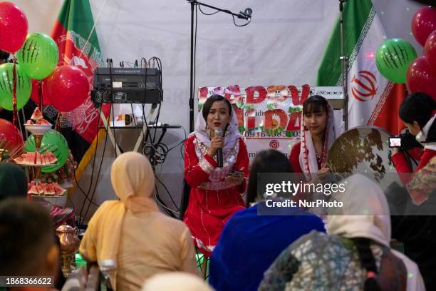 An Afghan refugee woman is singing a song in traditional attire while another woman is playing an Iranian traditional musical instrument during the...