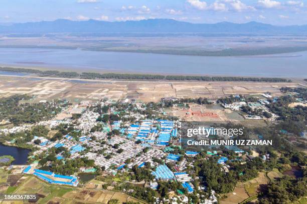 This aerial photograph taken on November 24, 2023 shows a view of the Nayapara Rohingya refugee camp, along the Naf river at Teknaf in Bangladesh's...