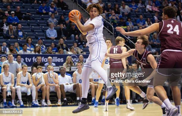 Marcus Adams Jr., #23 of the Brigham Young Cougars grabs a rebound away from Billy Smith and Eli Roberts of the Bellarmine Knights during the second...