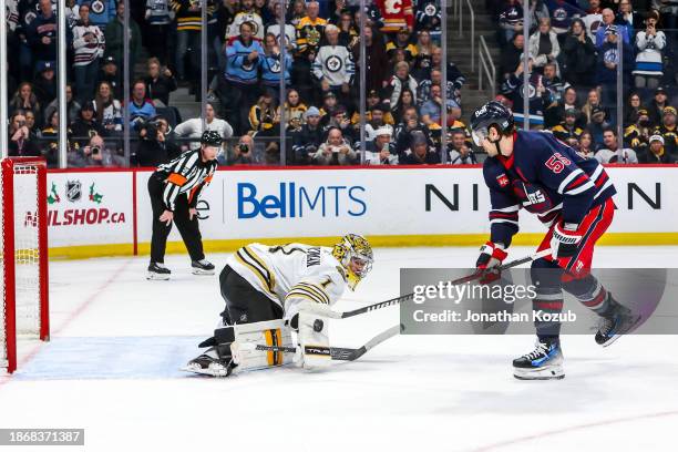 Goaltender Jeremy Swayman of the Boston Bruins makes a blocker save on Mark Scheifele of the Winnipeg Jets during a second period penalty shot at the...
