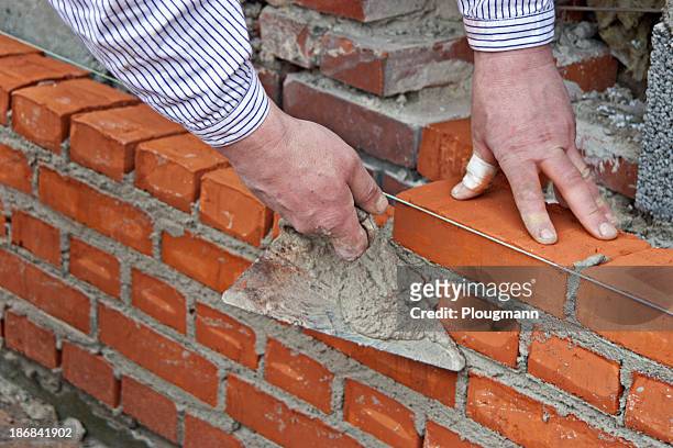 bricklayer raising a wall - mason bricklayer stock pictures, royalty-free photos & images
