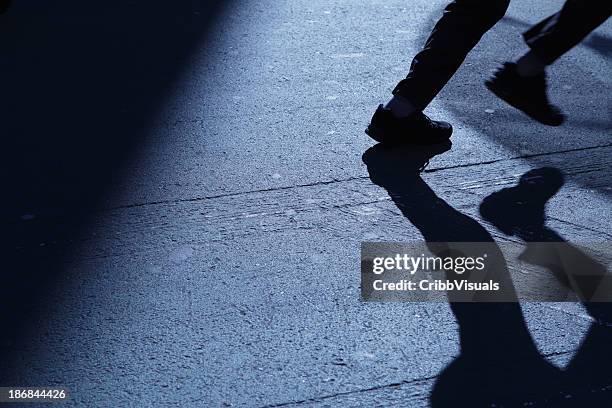 lone man running away in blue night shadows - dark street stock pictures, royalty-free photos & images