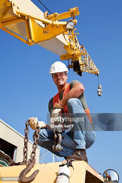 bauarbeiter auf kran mit edelstahl-haken - crane hook stock-fotos und bilder