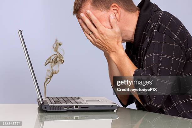 troubled man with smoking laptop computer - overheated stock pictures, royalty-free photos & images