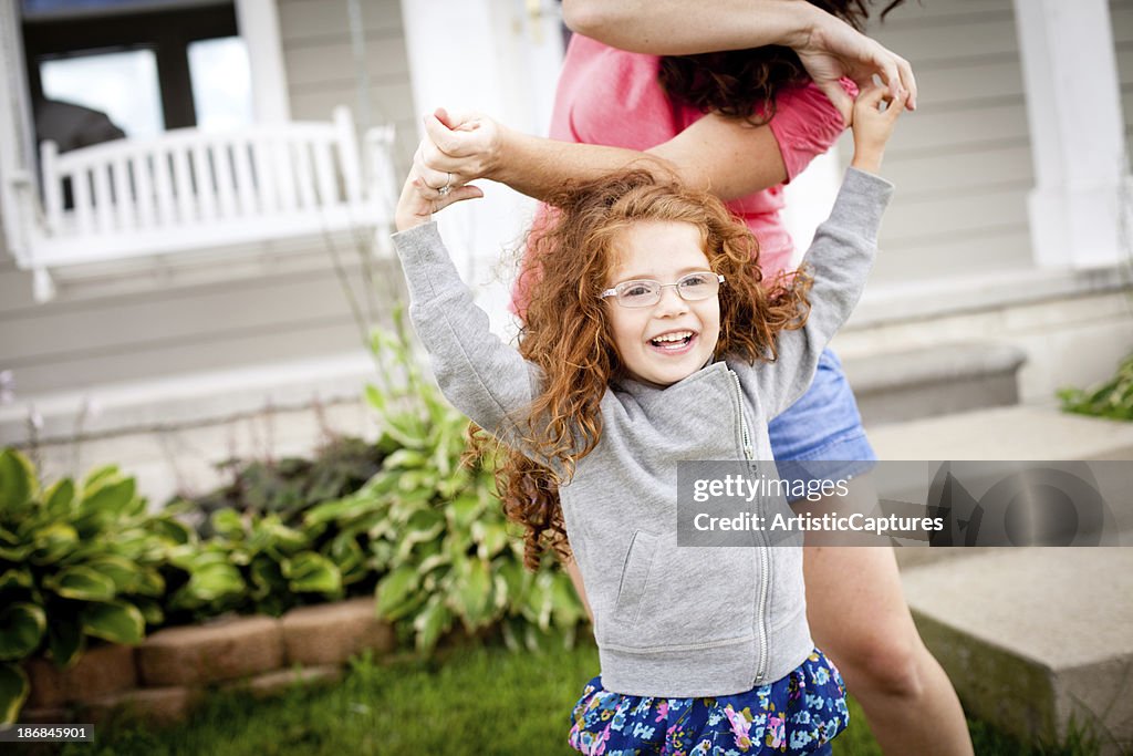 Farbe Bild von Mutter Tanzen im Freien mit Ihr kleines Mädchen
