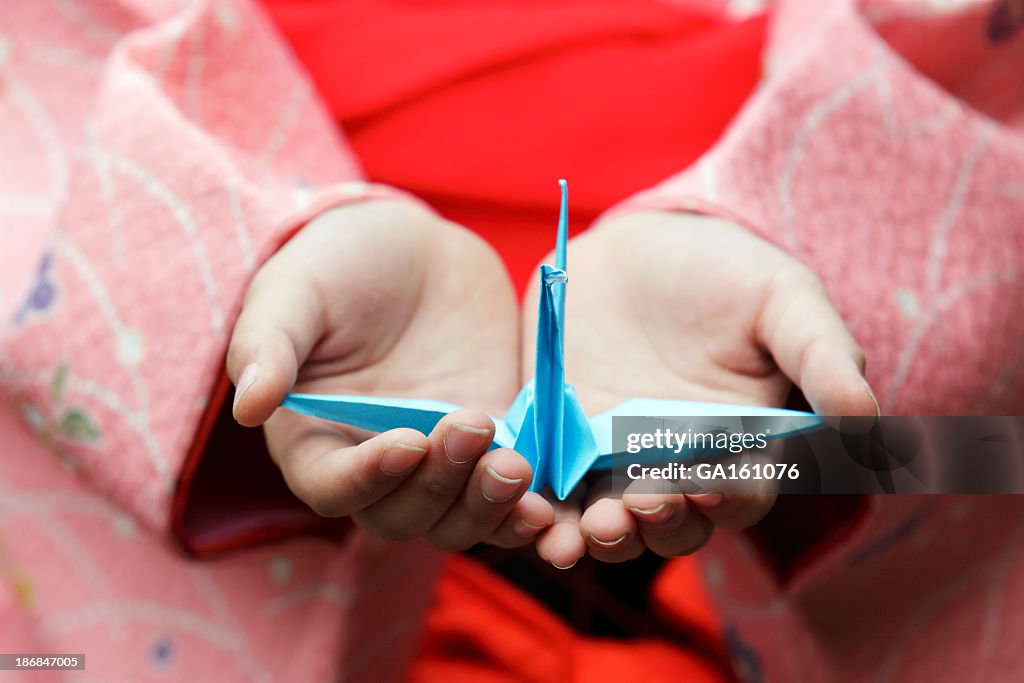 Girl hands holding an origami crane
