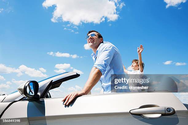 father and son inside of the convertible car. - man driving sports car stock pictures, royalty-free photos & images