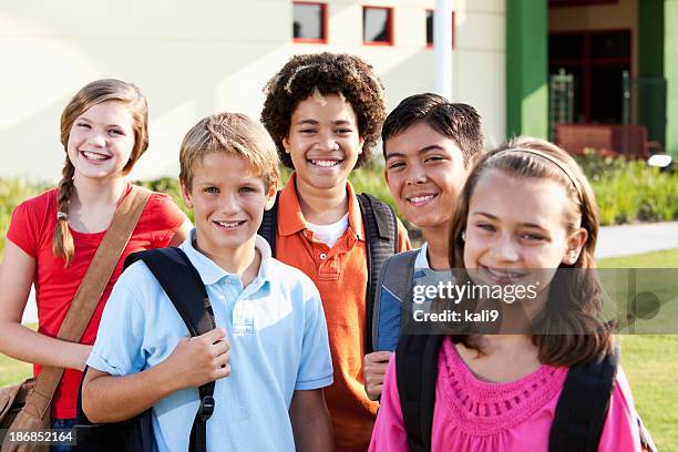 bambini in piedi fuori scuola con cartella, - educazione secondaria di scuola media foto e immagini stock