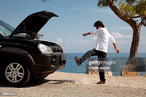 man having car problems kicking dirt in frustration - kicking tire stock pictures, royalty-free photos & images