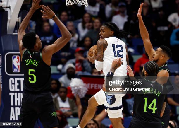 Ja Morant of the Memphis Grizzlies passes the ball around Herbert Jones of the New Orleans Pelicans at Smoothie King Center on December 19, 2023 in...