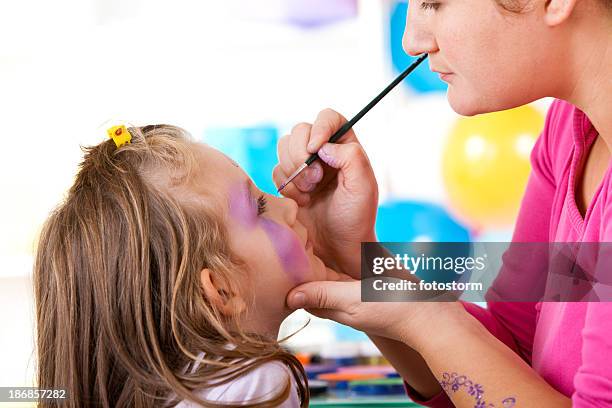 little girl having face painted on birthday party - kids makeup face stock pictures, royalty-free photos & images