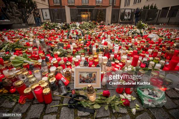 Candles flowers and photos of victims are placed outside the building of Charles University following a mass shooting earlier this week, on December...