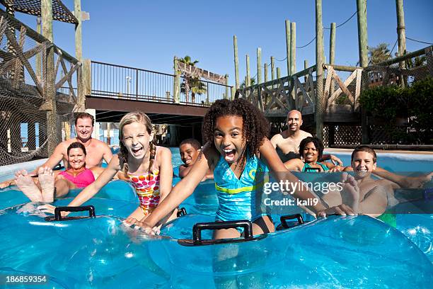 smiling group at water park in innertubes - water park stock pictures, royalty-free photos & images