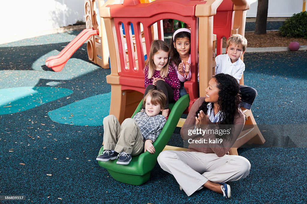 Preschoolers at daycare on playground with teacher