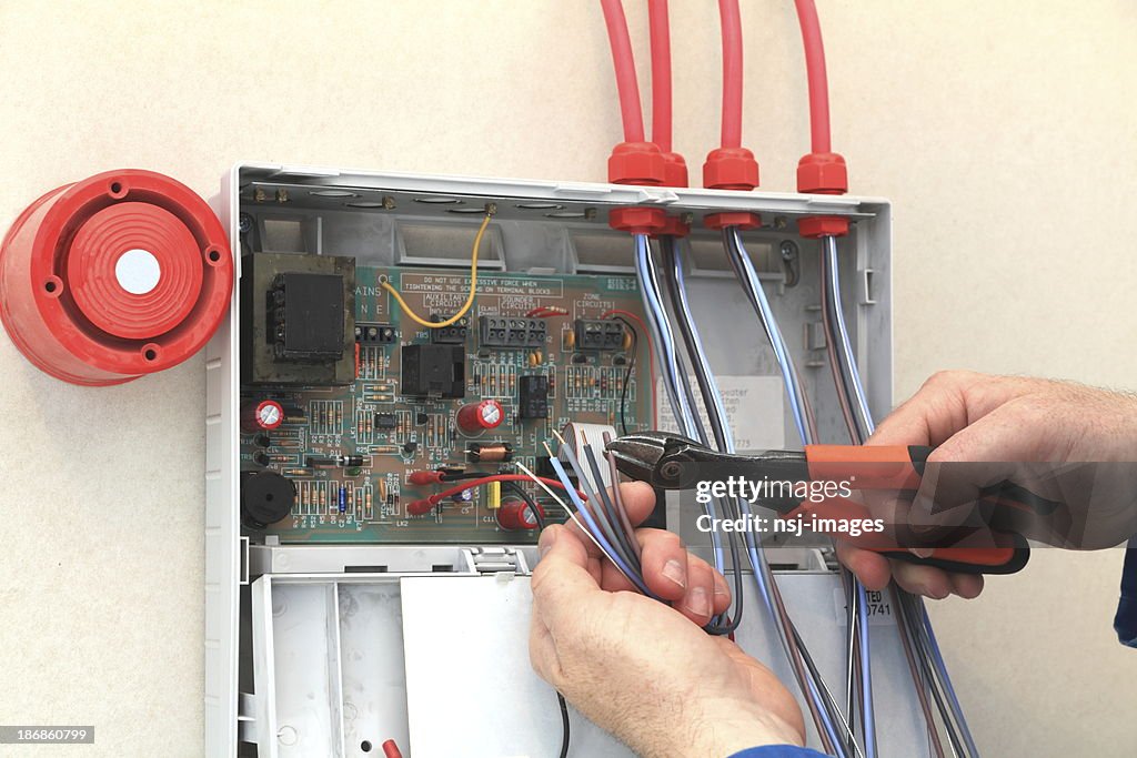 Electrician working at a Fire Alarm control box.