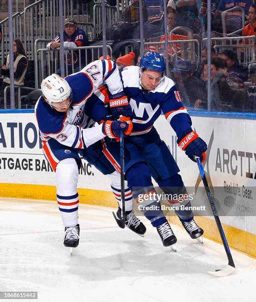 Julien Gauthier of the New York Islanders wards off Vincent Desharnais of the Edmonton Oilers during the second period at UBS Arena on December 19,...