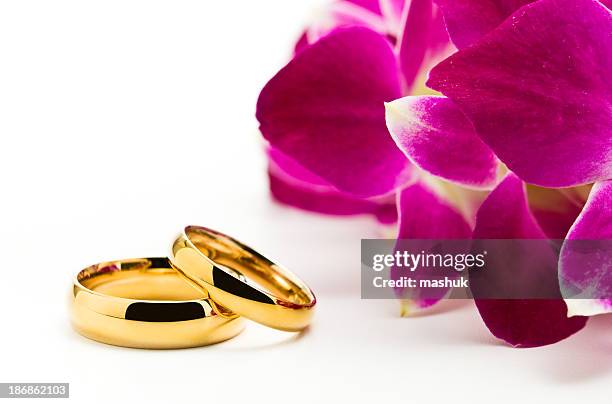 hochzeitsringe und orchideen - trauringe gold stock-fotos und bilder