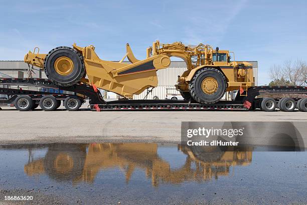 earth mover on trailer - extra groot stockfoto's en -beelden