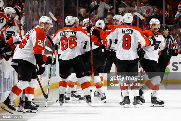 The Philadelphia Flyers celebrate with Owen Tippett after his game-winning goal during overtime against the New Jersey Devils at Prudential Center on...