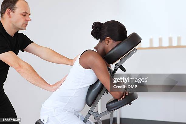 donna in una sedia da massaggio alla testa - massaggiare foto e immagini stock
