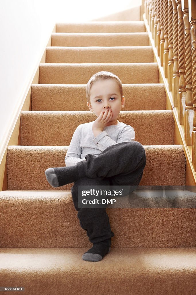 Little innocent boy sitting on stairs