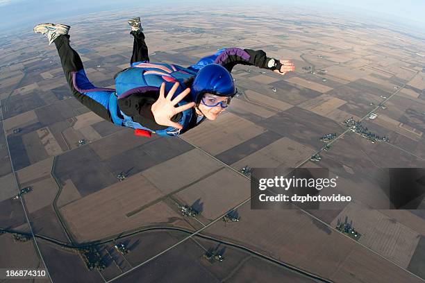 young lady skydiving whilst mid-air waving to camera - farm bailout bildbanksfoton och bilder