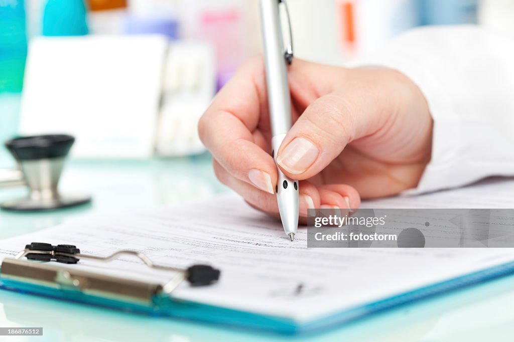 Doctor writing a prescription on medical exam