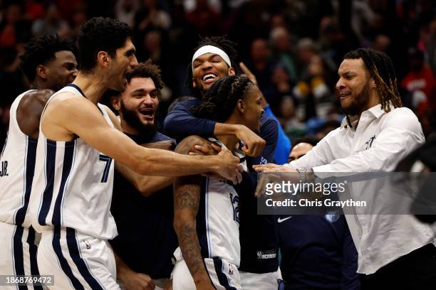 Ja Morant of the Memphis Grizzlies reacts with his team after defeating the New Orleans Pelicans at Smoothie King Center on December 19, 2023 in New...