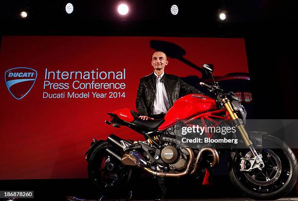 Claudio Domenicali, chief executive officer of Ducati Motor Holding SpA, a unit of Audi AG, poses beside a new Ducati Monster motorbike at the end of...