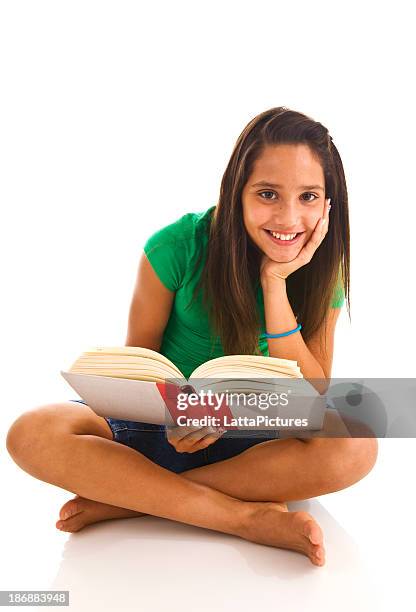 young female teenager sitting cross legged reading a book - teenager learning child to read stockfoto's en -beelden