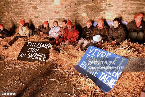 People sit with placards during a demonstration of employees of Tilly-Sabco, an agrofood entreprise in financial difficulties, in a courtyard of the...