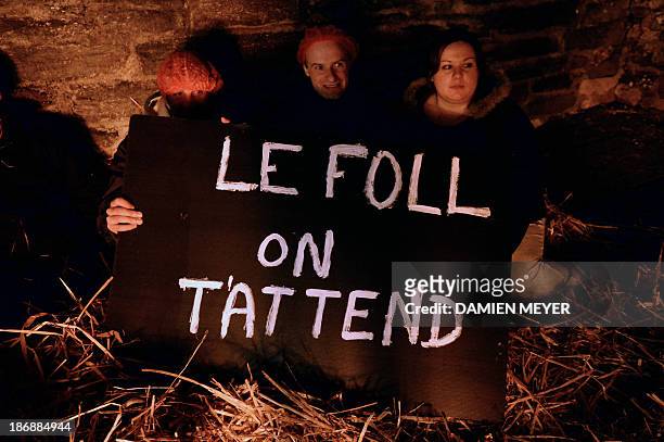 People sit with a placard during a demonstration of employees of Tilly-Sabco, an agrofood entreprise in financial difficulties, in a courtyard of the...