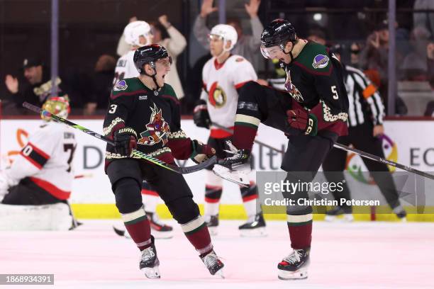 Michael Kesselring of the Arizona Coyotes celebrates with Josh Brown after scoring a goal against goaltender Joonas Korpisalo of the Ottawa Senators...