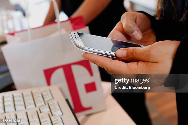 An employee sets up a new Samsung Electronics Co. Galaxy 3 smartphone for a customer at a T-Mobile US Inc. Retail store in Torrance, California,...