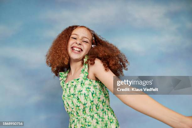 cheerful redhead girl in floral green dress dancing - oberkörper happy sommersprossen stock-fotos und bilder