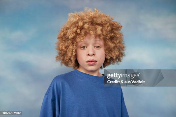 albino boy with blond afro hairstyle in blue t-shirt - hazel eyes stock pictures, royalty-free photos & images