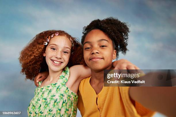 multiracial girls taking selfie with arms around - middle childhood stock pictures, royalty-free photos & images