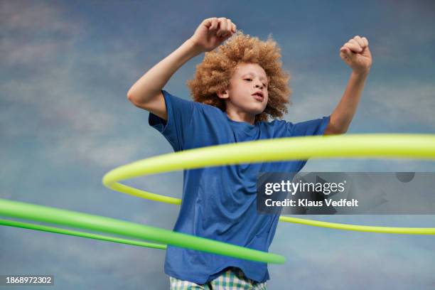 confident albino boy spinning green plastic hoops - albino stockfoto's en -beelden