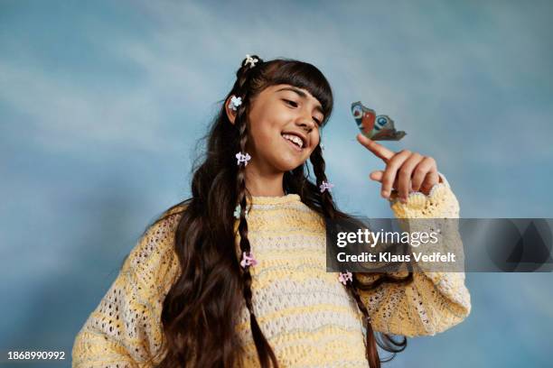 smiling girl looking at butterfly on finger - crochet stock pictures, royalty-free photos & images