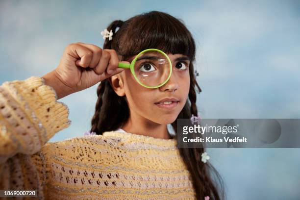 girl looking through magnifying glass - budding tween stock pictures, royalty-free photos & images