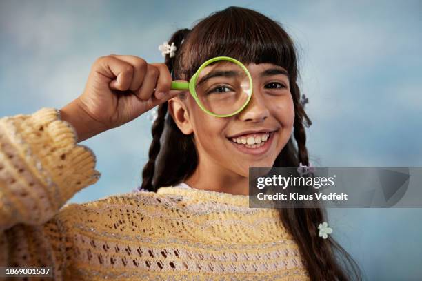 smiling girl looking through magnifying glass - iranian people stock pictures, royalty-free photos & images