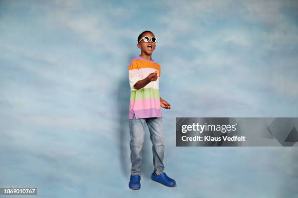 boy wearing sunglasses gesturing with mouth open - multi coloured trousers stock pictures, royalty-free photos & images