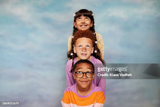 friends leaning on heads while looking up - budding tween stock pictures, royalty-free photos & images