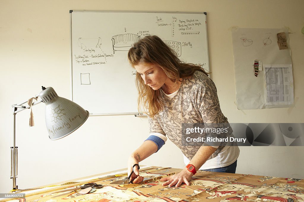 Upholsterer cutting fabric