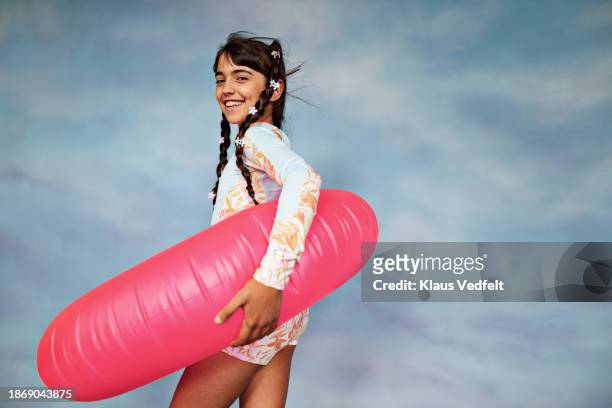 smiling girl standing with pink inflatable ring - tween girls swimwear stock pictures, royalty-free photos & images