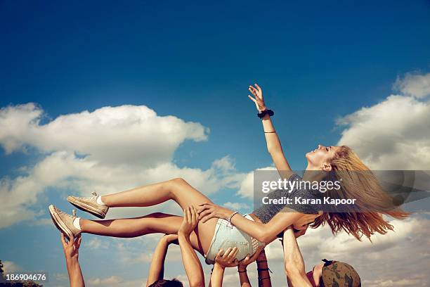 female teenager held up triumphantly - mosh pit woman stock pictures, royalty-free photos & images