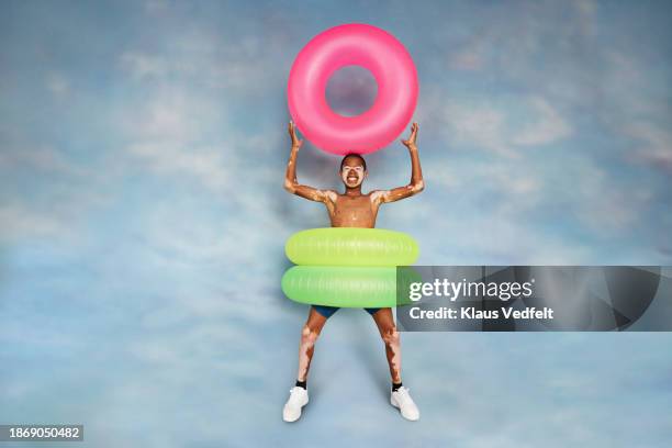 happy boy with vitiligo carrying inflatable ring - recreational equipment stock pictures, royalty-free photos & images