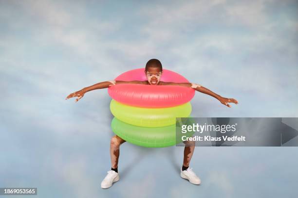 playful smiling boy with vitiligo wearing inflatable rings - recreational equipment stock pictures, royalty-free photos & images